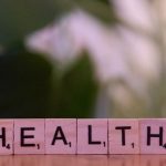 A wooden block spelling the word health on a table
